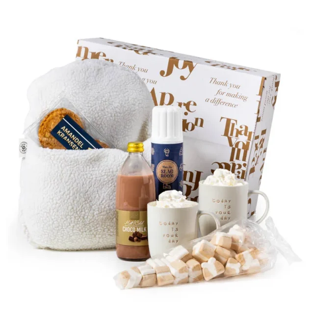 Geschenkdoos met witte pantoffel, twee beige mokken en chocomelk