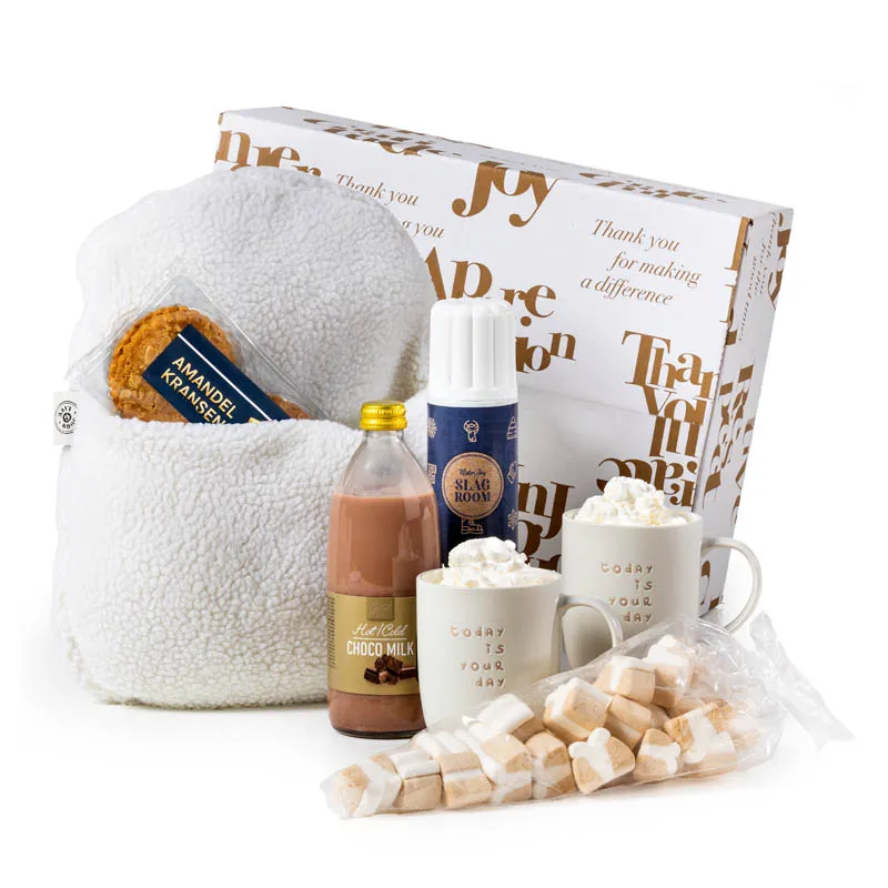 Geschenkdoos met witte pantoffel, twee beige mokken en chocomelk